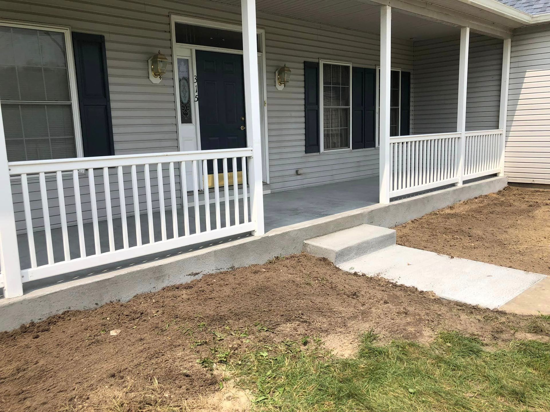 A house with a porch and a walkway in front of it.