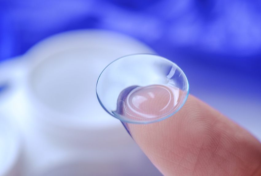 A finger holding a contact lens