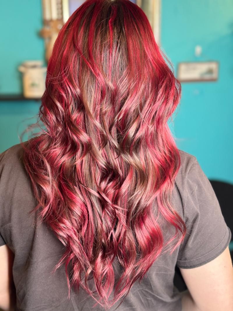 A woman with long red hair is wearing a gray shirt.