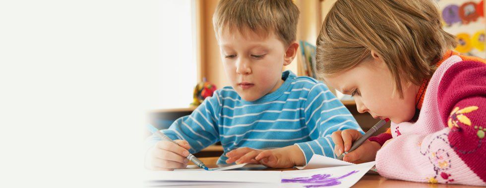 Two little children writting on a paper