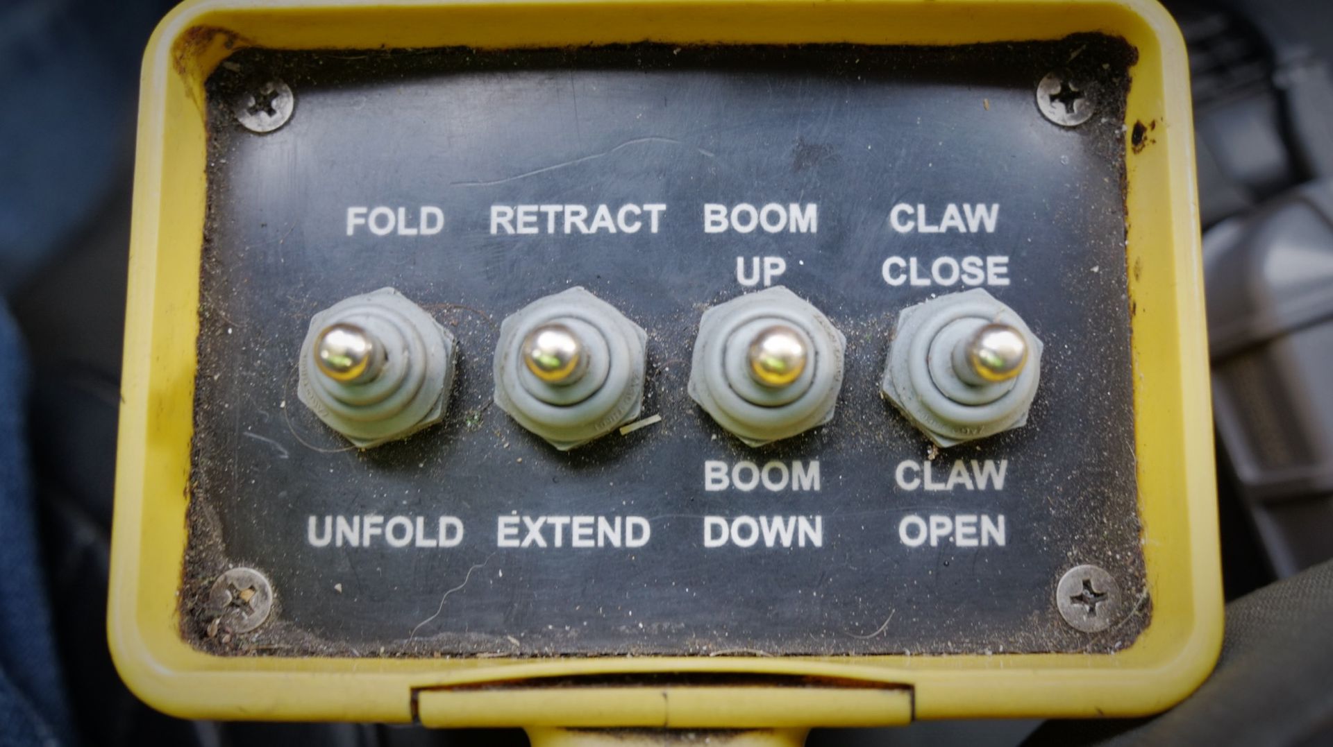 Yellow control panel with four toggle switches labeled: Fold/Unfold, Retract/Extend, Boom Up/Down, Claw Close/Open.