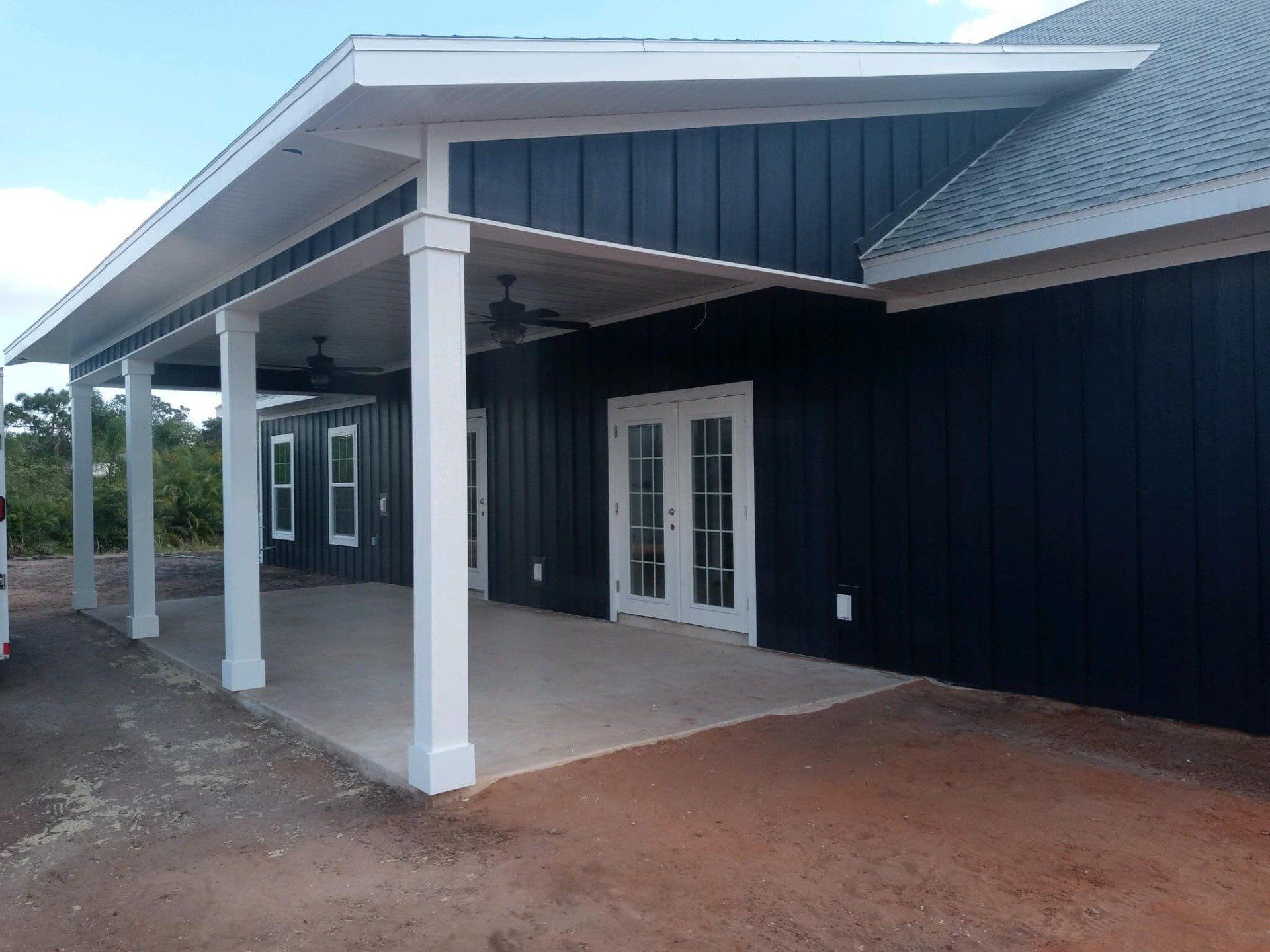 Dark blue house with white trim and a covered porch.