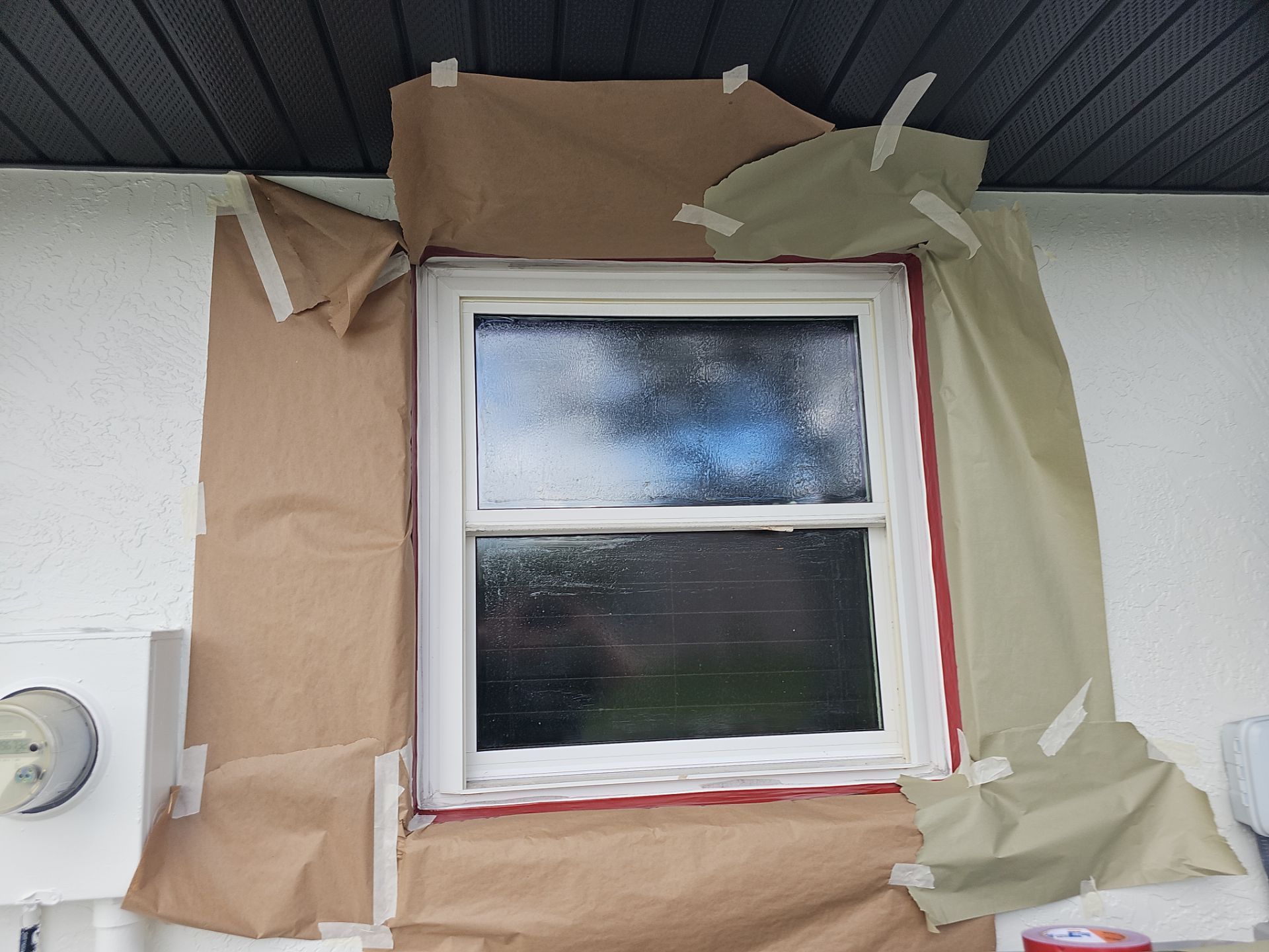 Window covered in brown paper and tape, ready for painting.