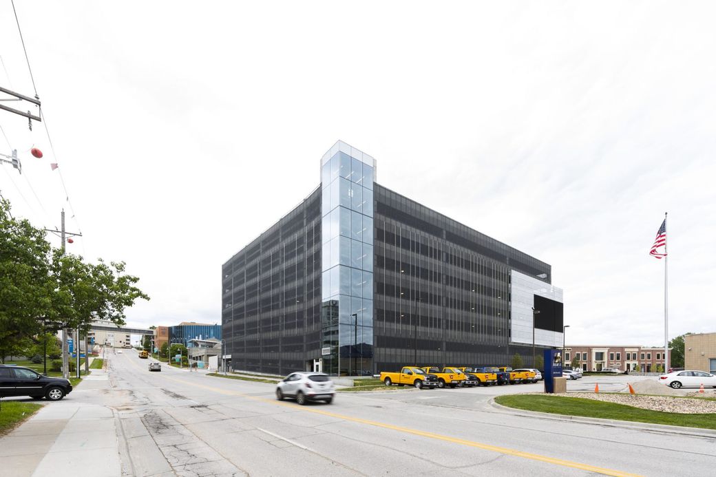 Modern black office building on a city street with several yellow taxis parked nearby