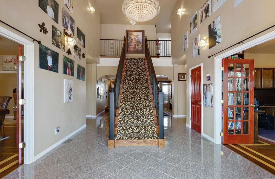 A large hallway with a staircase and a chandelier.