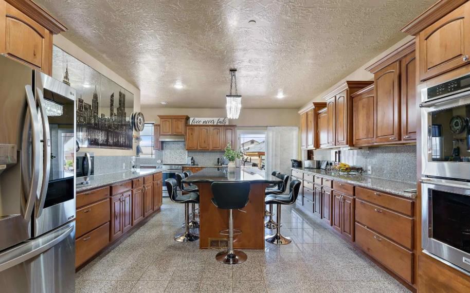 A large kitchen with stainless steel appliances and wooden cabinets.