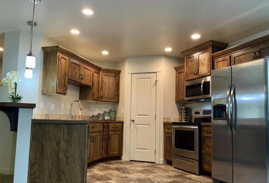 A kitchen with stainless steel appliances and wooden cabinets.