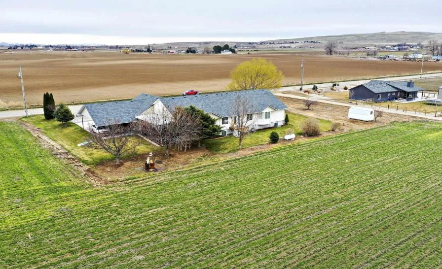 An aerial view of a house in the middle of a field.