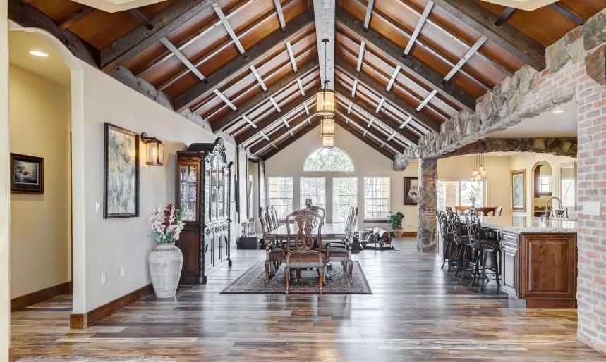 A large living room with a vaulted ceiling and wooden floors.