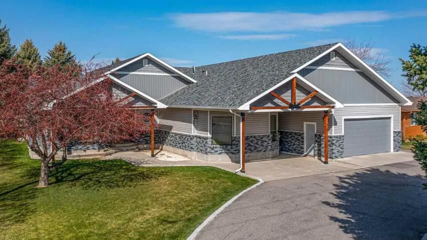 A large house with a gray roof and a garage is for sale.