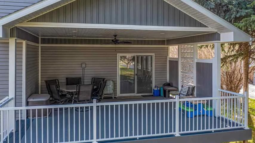 There is a porch with a table and chairs on it.