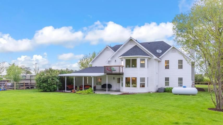 A large white house with a large lawn in front of it.