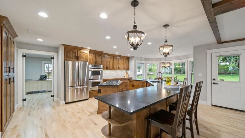 A kitchen with a large island and stainless steel appliances.