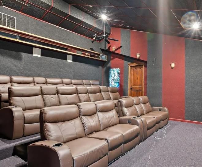 A movie theater with a lot of brown leather couches
