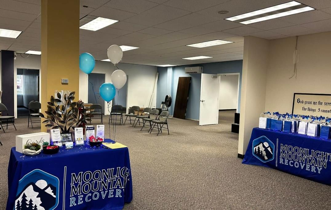 A large room with tables and balloons in it.