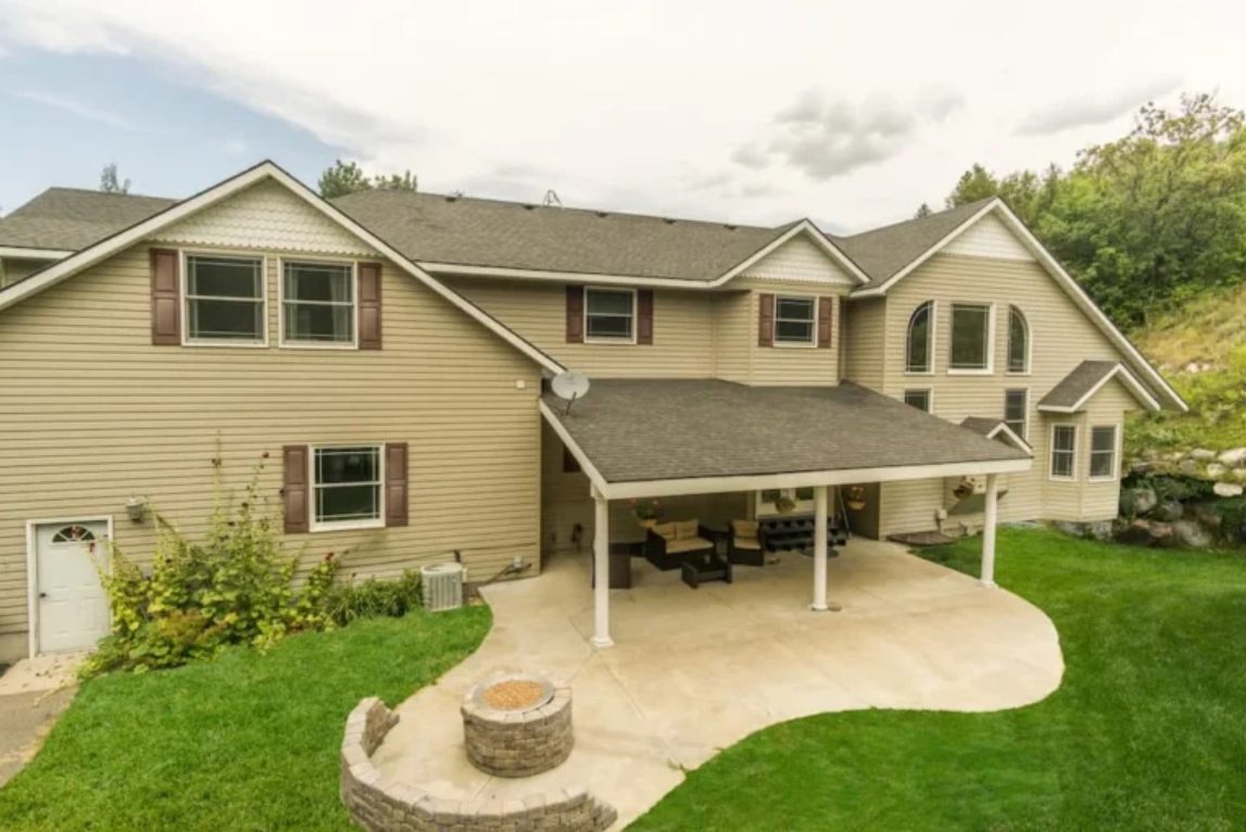 A large house with a covered patio and a fire pit