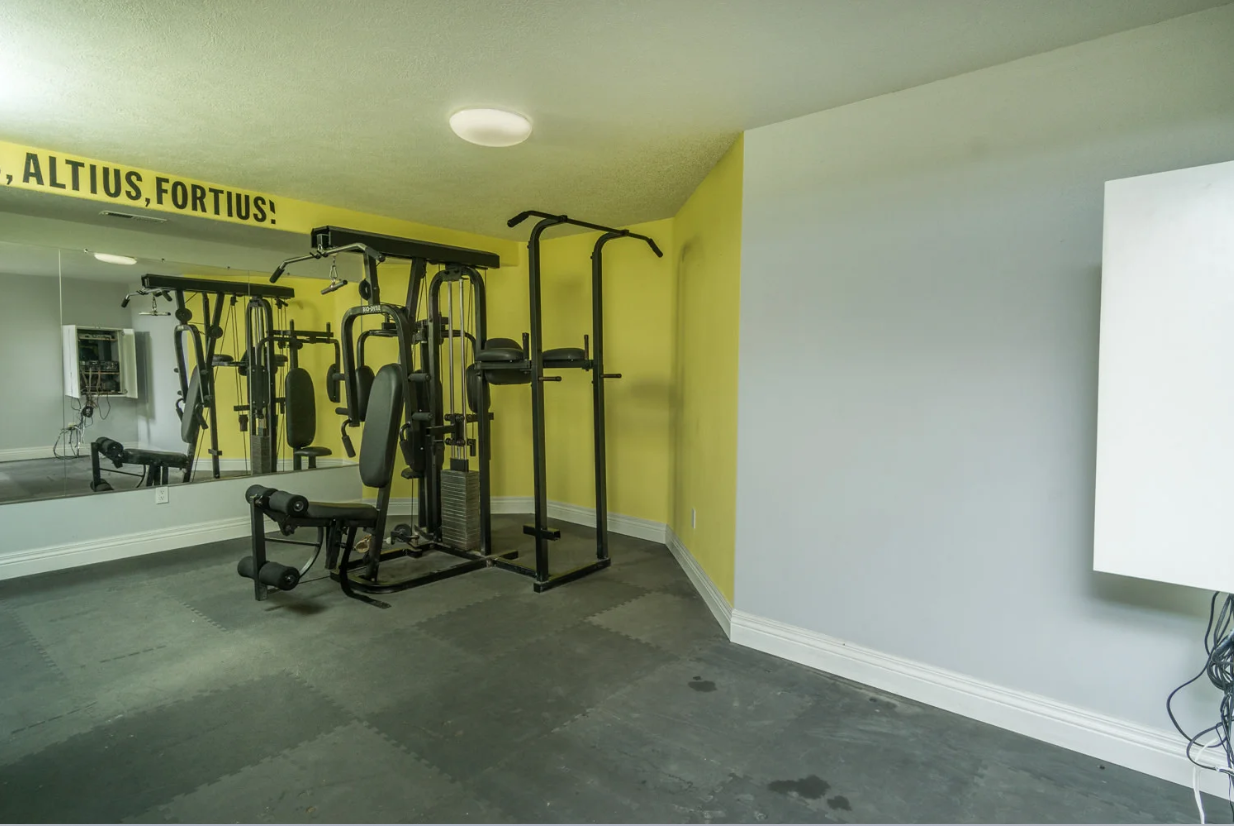 A gym with a lot of equipment and a large mirror
