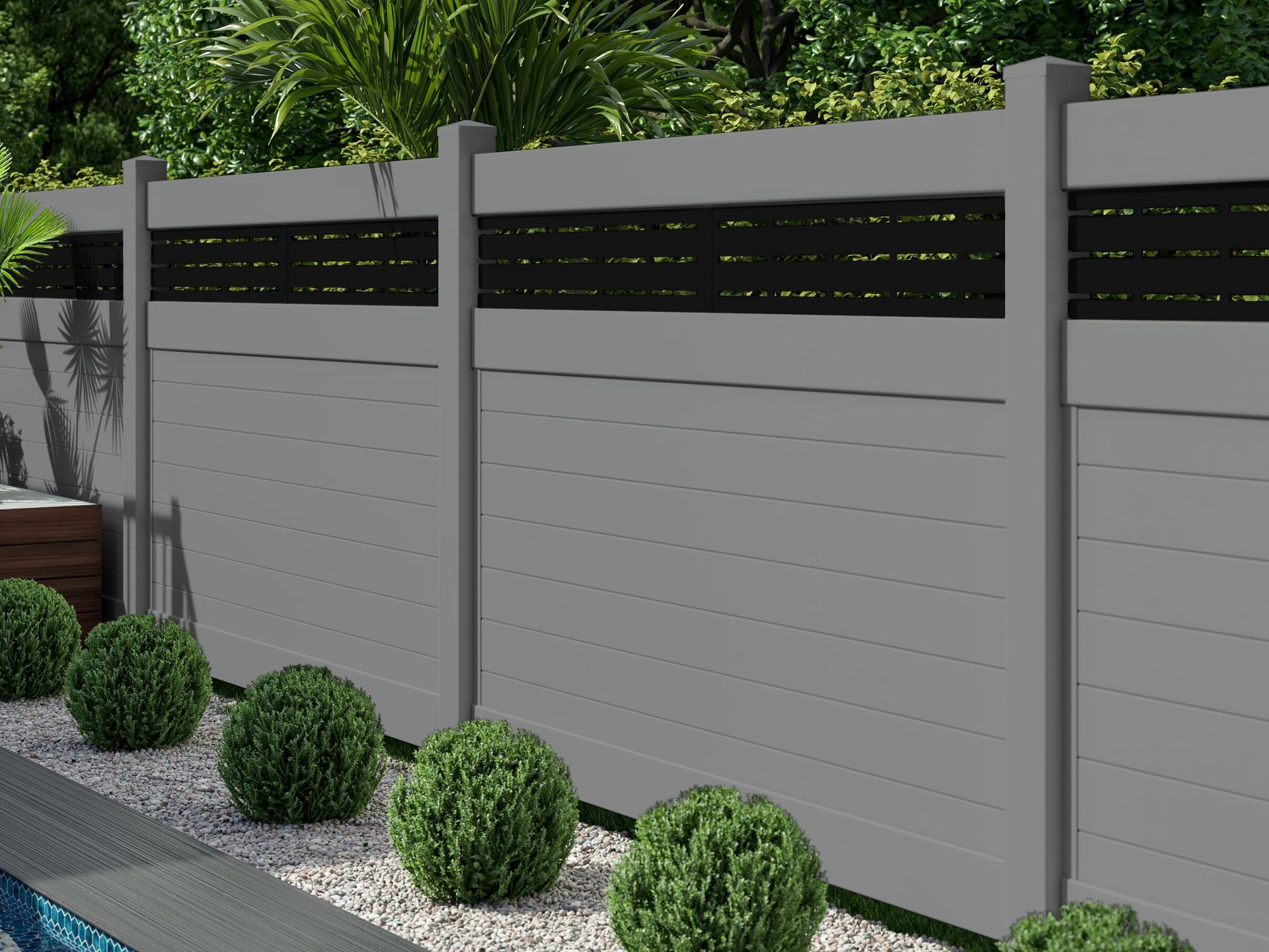 Gray privacy fence with black slat panels beside a gravel path and trimmed shrubs