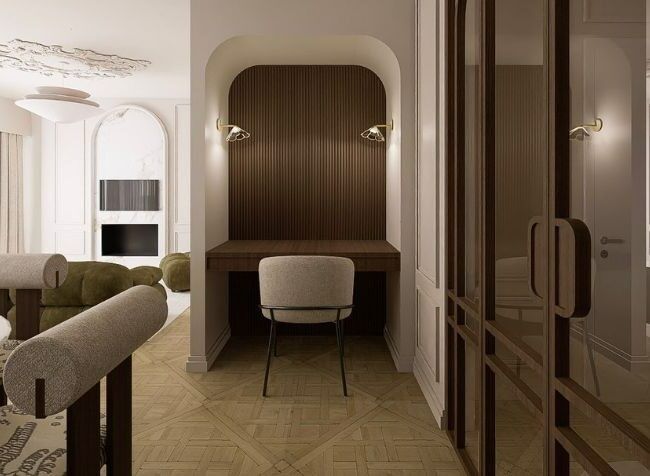 Elegant cream-toned room with a built-in wood desk nook, upholstered chair, and glass-front wardrobe