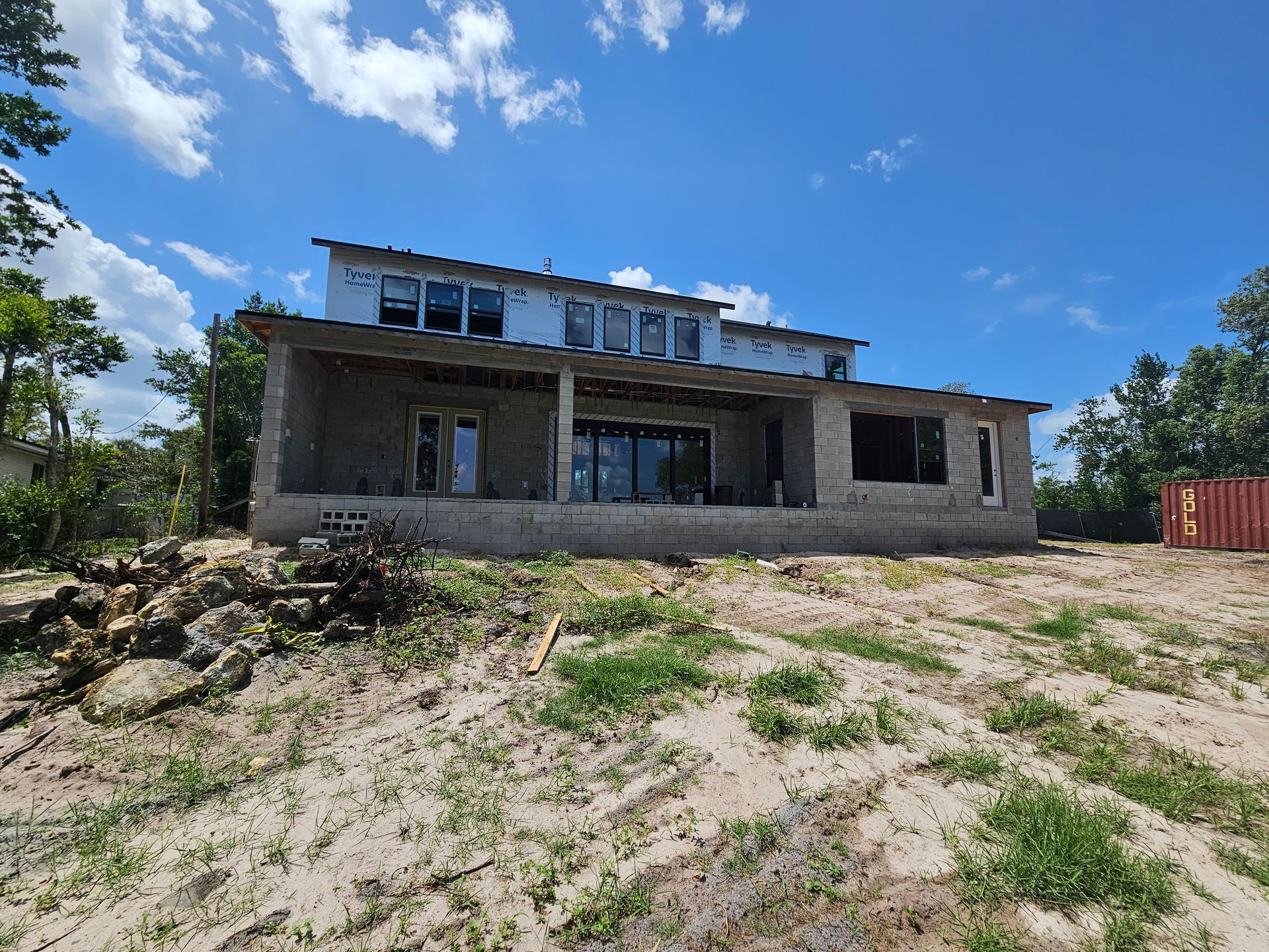 Abandoned unfinished concrete house on a sandy hillside under a bright blue sky