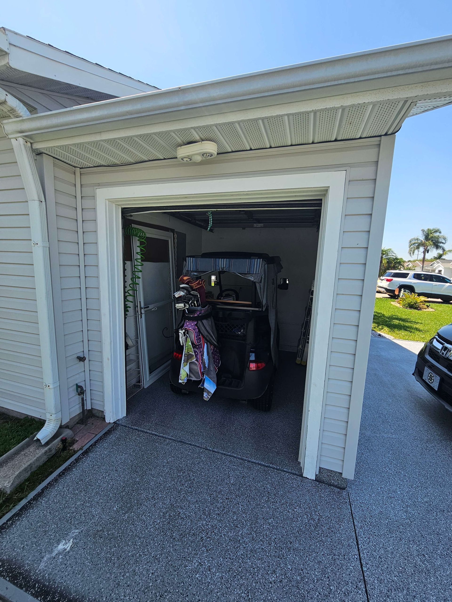 Garage entrance with a golf cart parked inside and white siding around the doorway