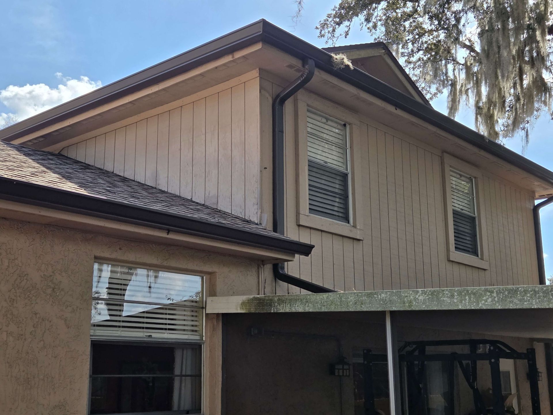 Exterior of a beige house with dark roof and covered patio