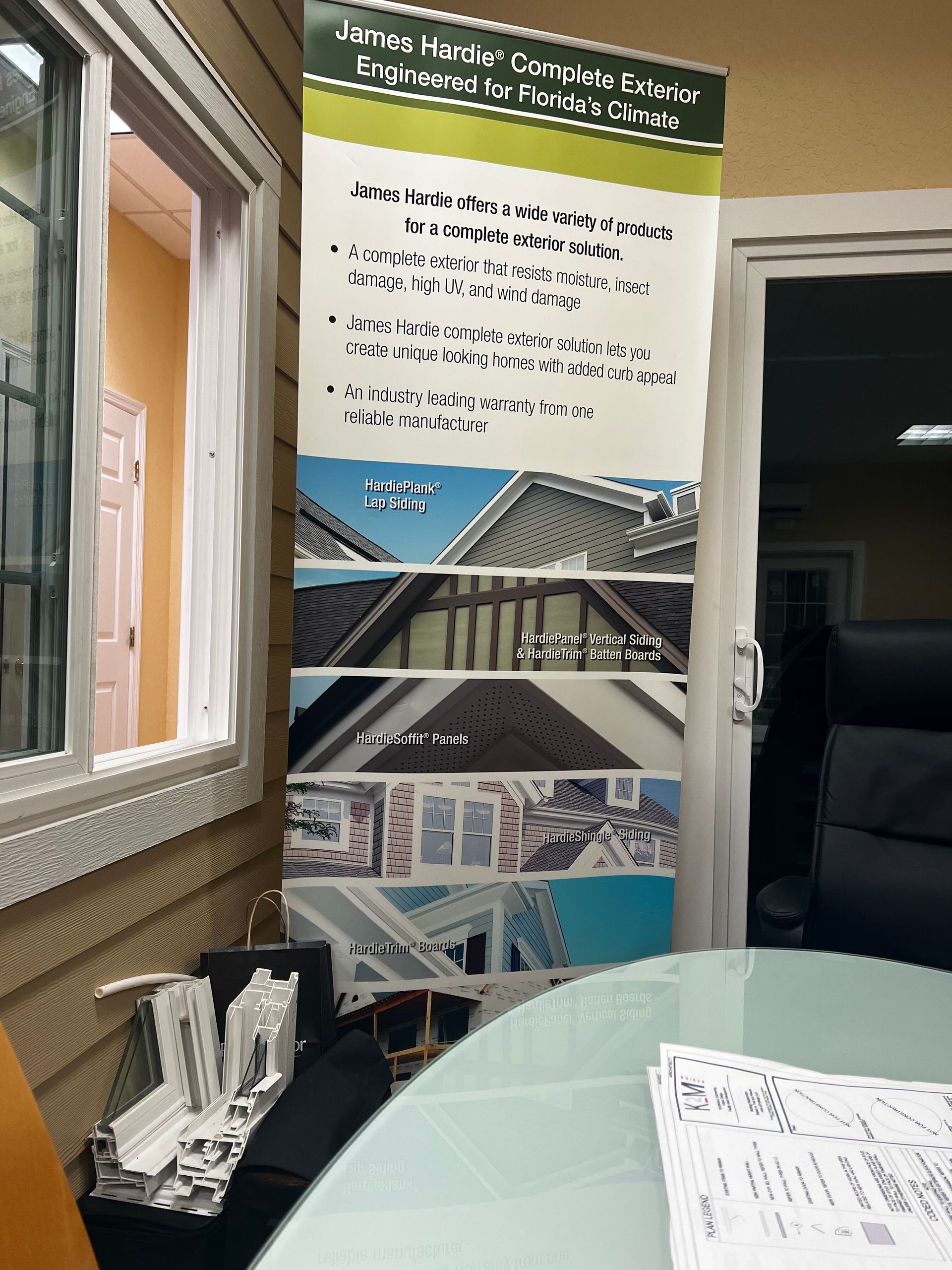 Banner and brochure display at an indoor exhibit, with photos and text about a building project.