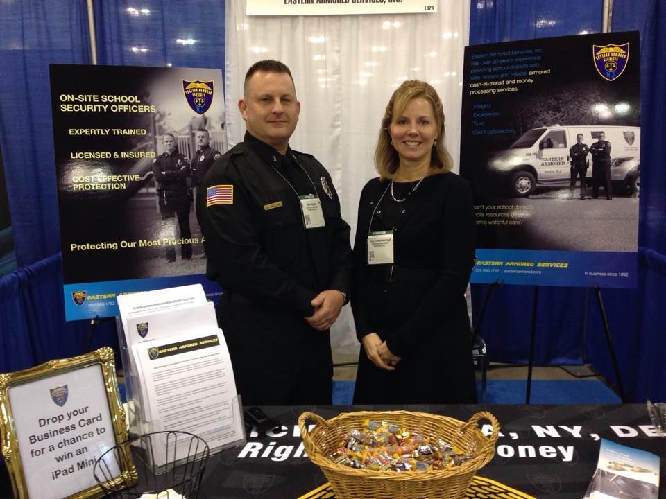 A man and a woman are standing in front of a table with a basket of candy on it