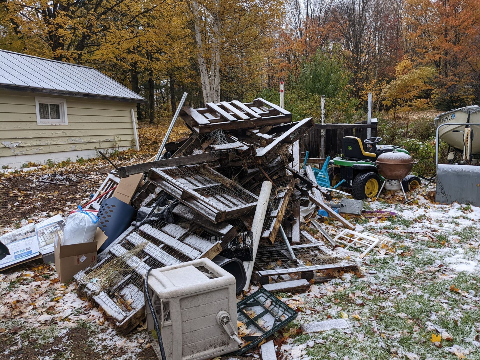 A pile of wooden pallets is sitting in front of a house.