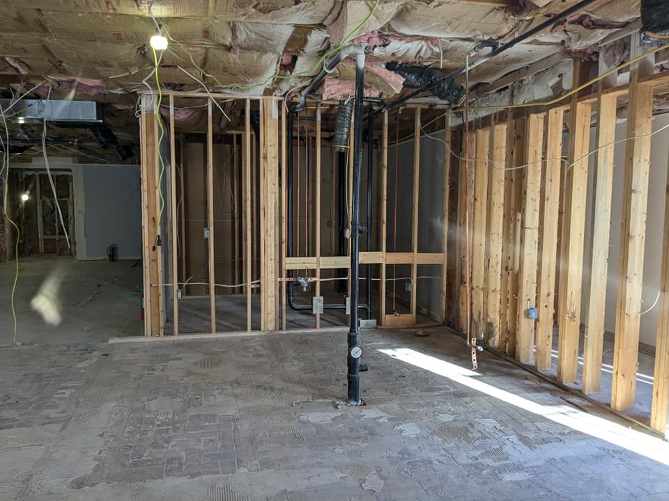 A room with a lot of wooden beams and pipes in it.