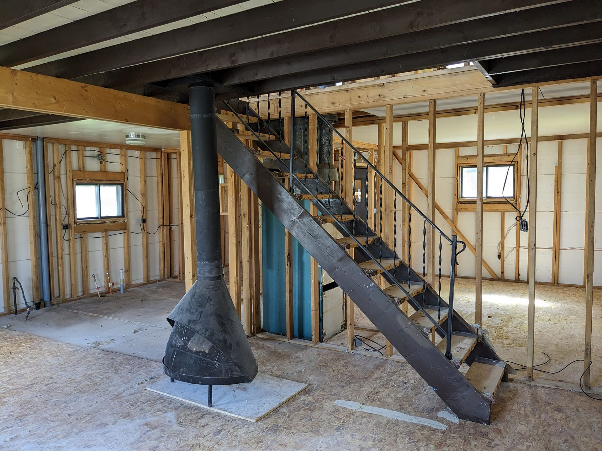 An empty room with a staircase and a fireplace