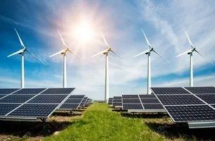 Solar panels and wind turbines in a field, generating renewable energy under a bright sky.