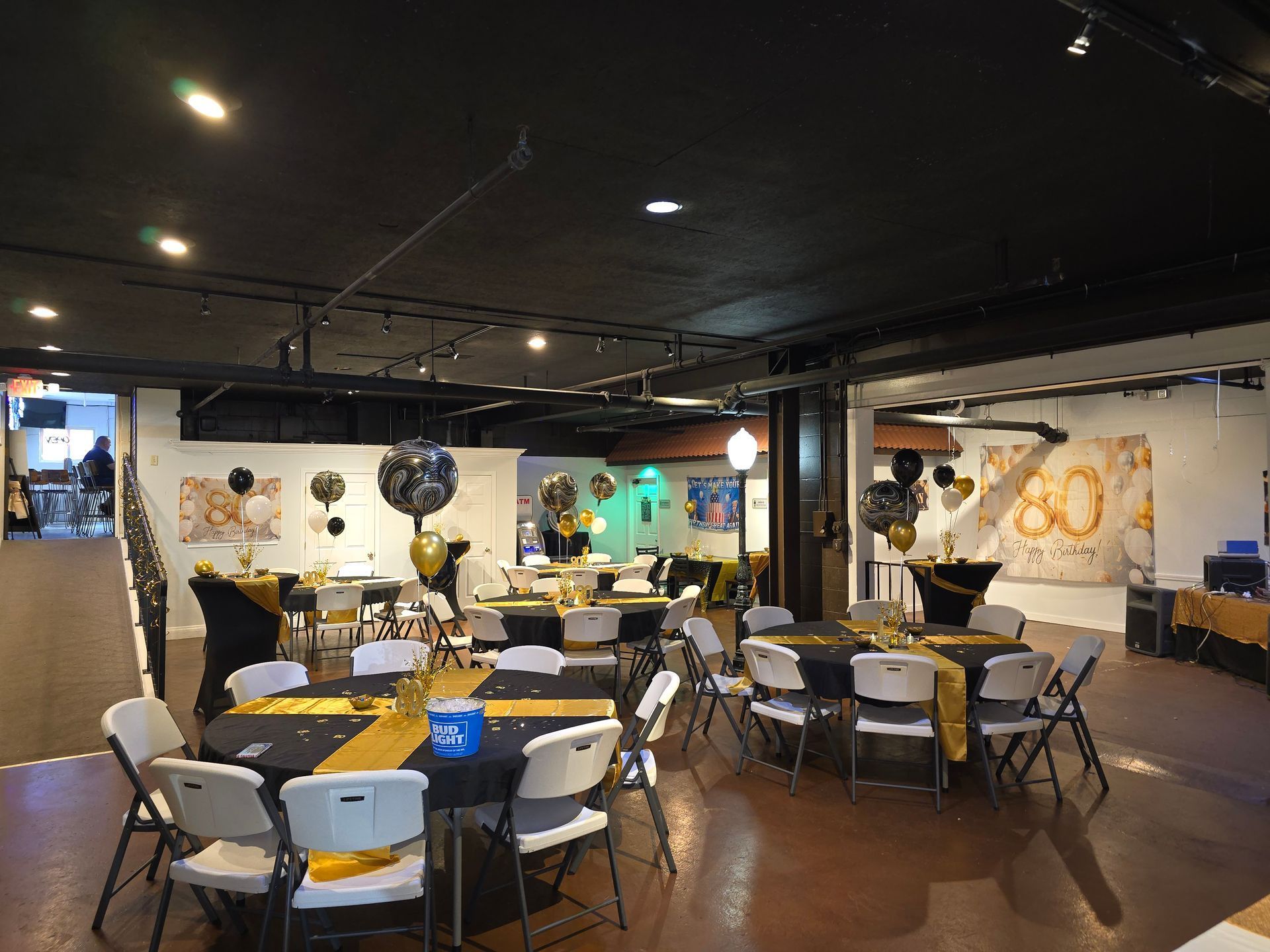 Banquet hall with black and gold decorations; tables and chairs arranged for a celebration.