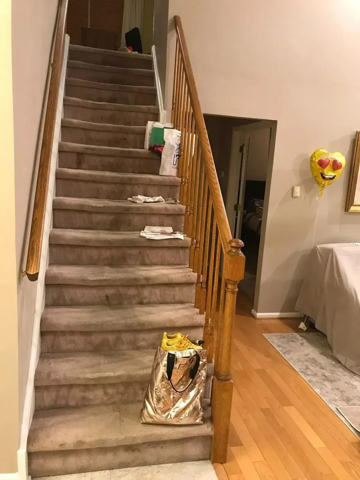 Staircase with brown carpet and wooden handrails.
