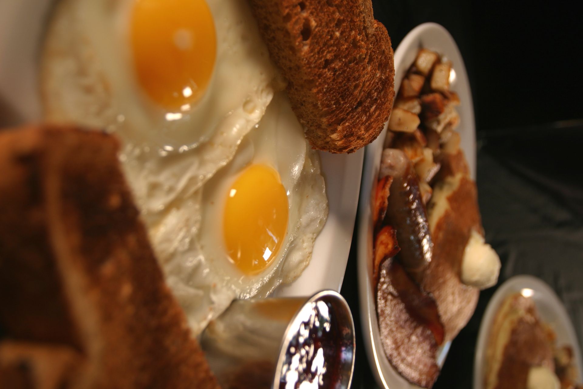 Overhead shot of a breakfast plate with eggs, toast, potatoes, and pancakes.
