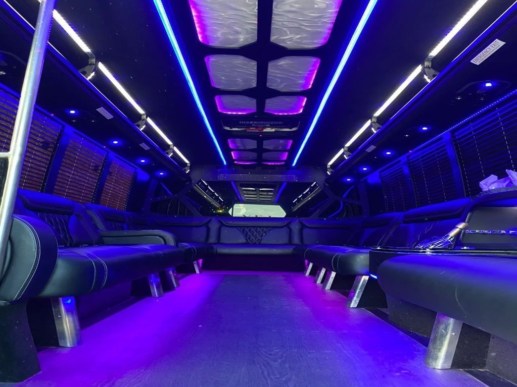 The inside of a limousine with purple lights on the ceiling.