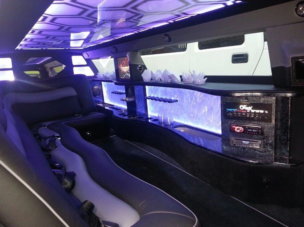 The inside of a limousine with purple lights on the ceiling