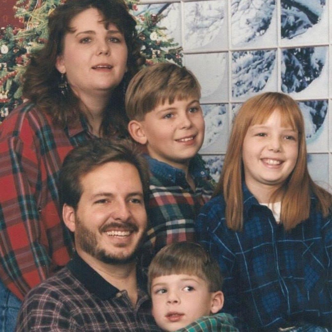 A family posing for a picture in front of a christmas tree