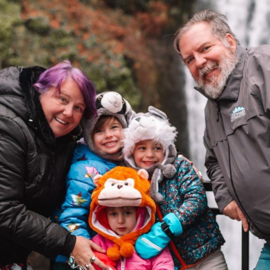 A group of people posing for a picture in front of a waterfall