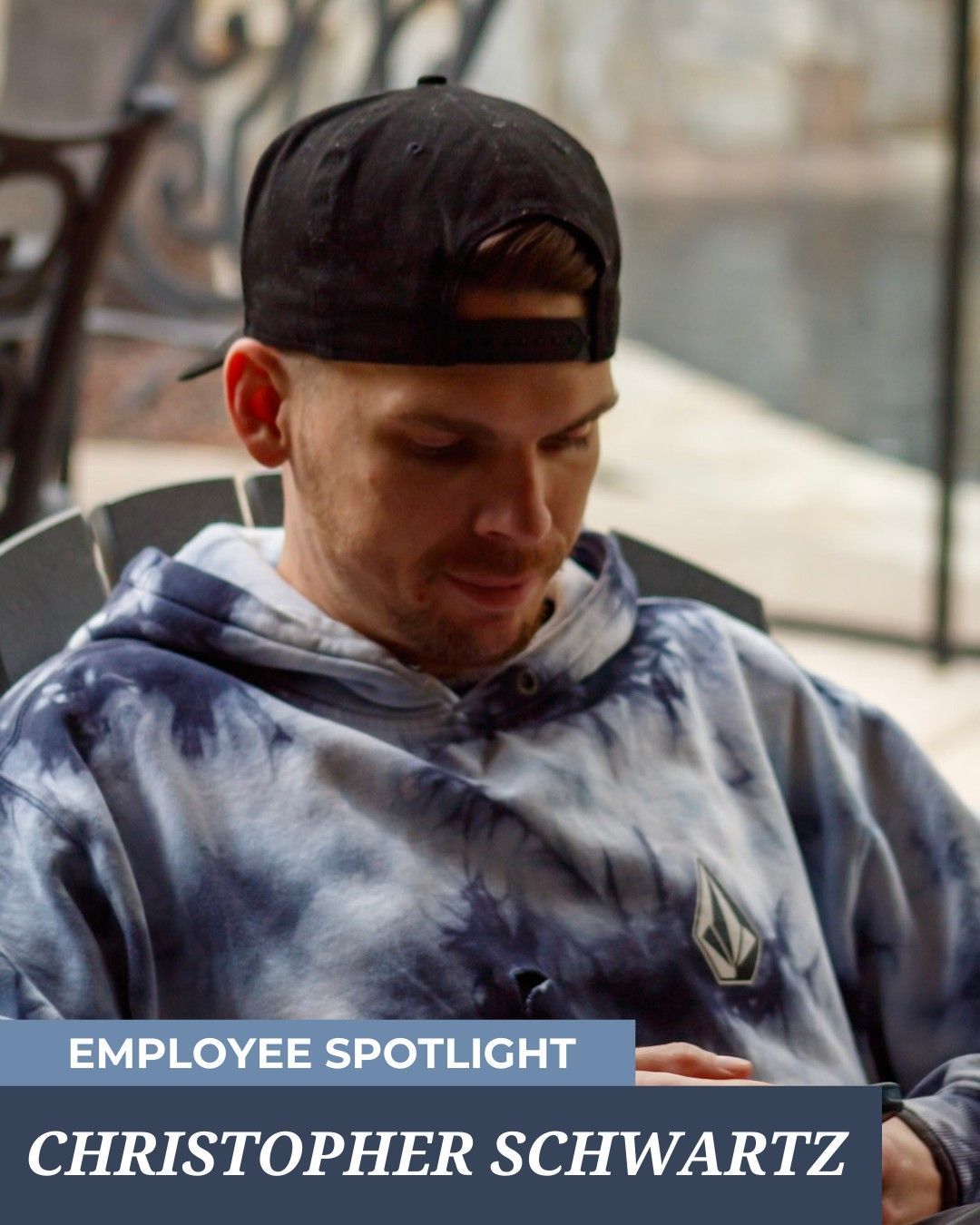 Christopher Schwartz in a black cap and tie-dye hoodie, looking down. 