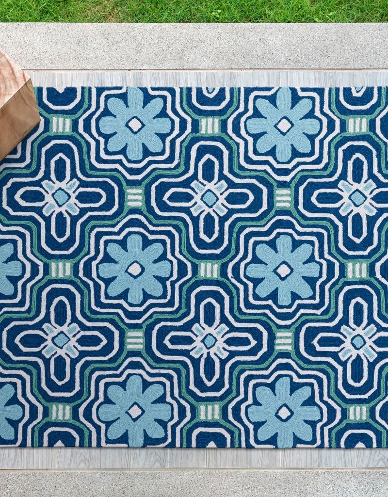 Blue patterned outdoor rug on a patio.