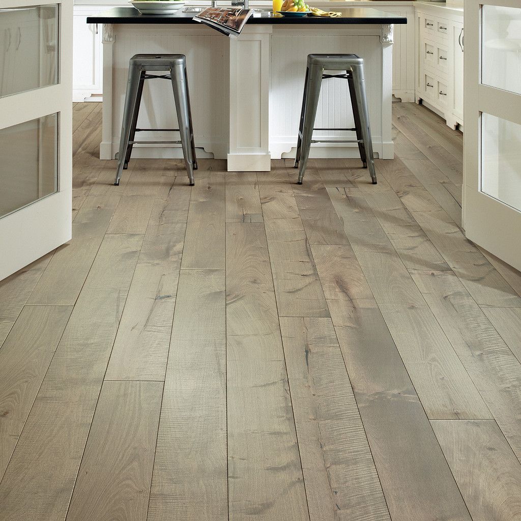 Hardwood floor in a kitchen with a white island and two metal stools.
