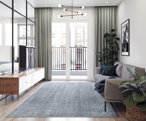 Living room with gray sofa, large rug, balcony, and modern decor.