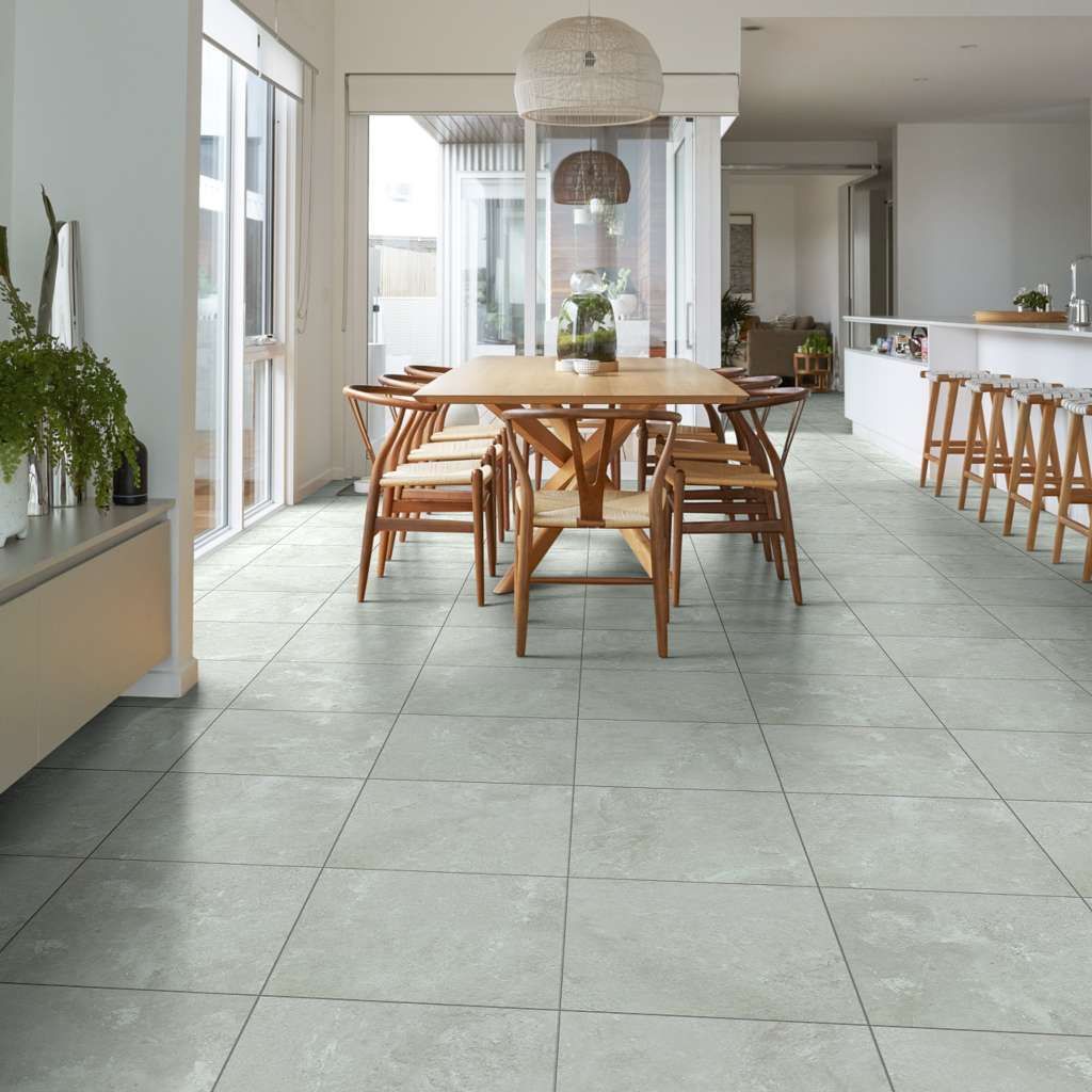 Dining room with wooden table, chairs, and light gray tile flooring.