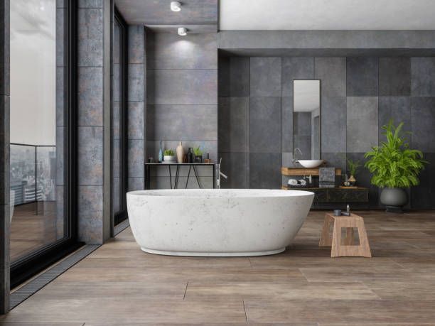 Modern bathroom with a white bathtub, dark gray walls, and wooden floors.