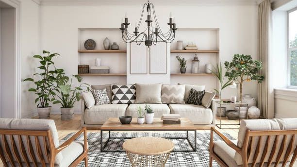 Living room with neutral tones, sofa, armchairs, plants, and shelves with decorative items.