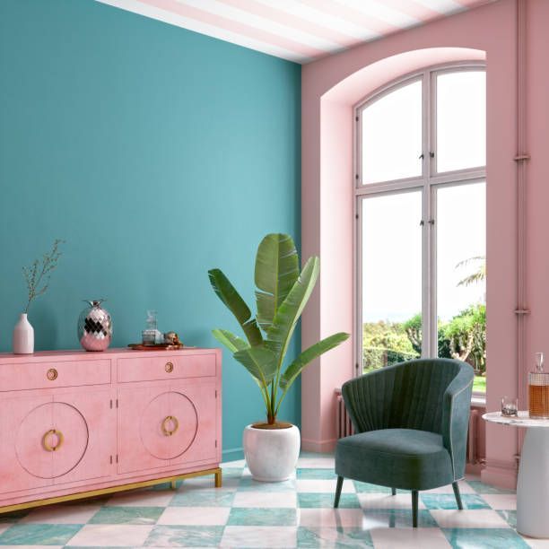 Pink and teal room with a cabinet, armchair, and large window.