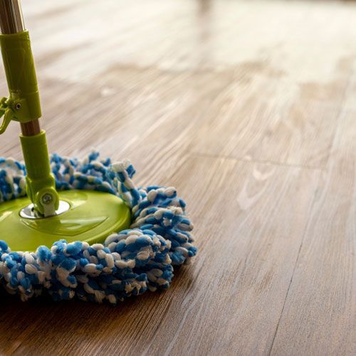 Green and blue mop cleaning a wooden floor.