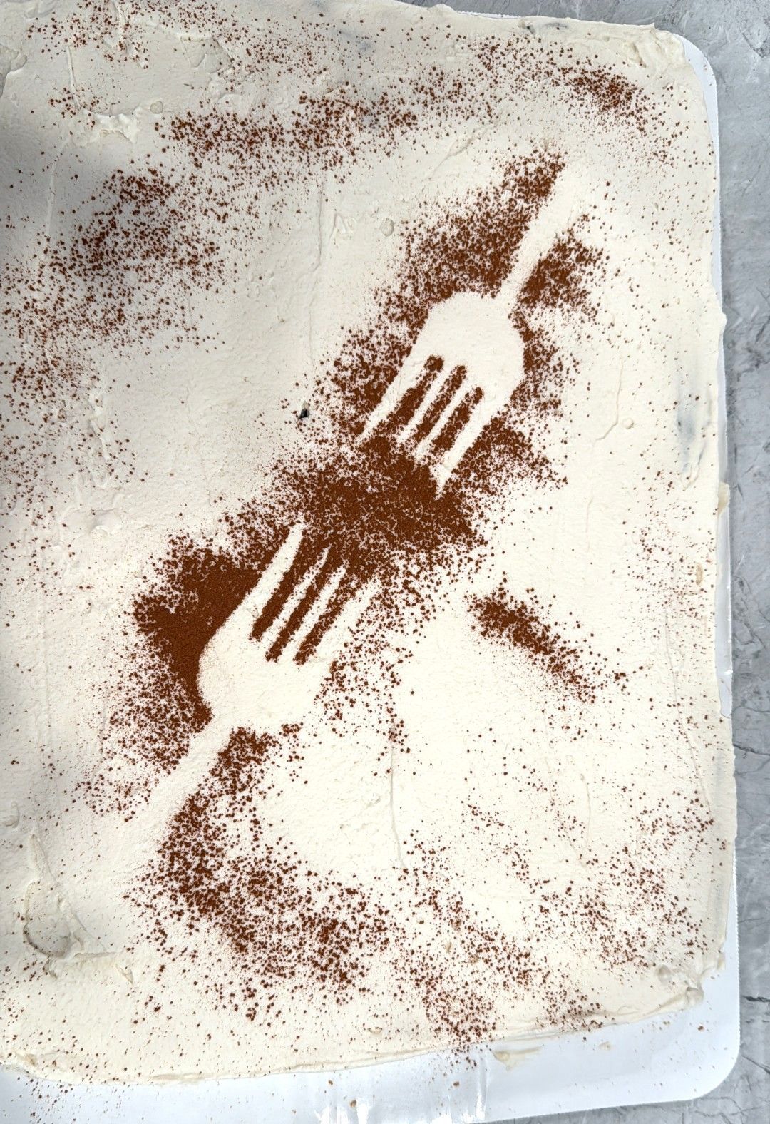 Rust-colored handprint and diagonal streaks on a white textured surface, like a paint or powder stencil.