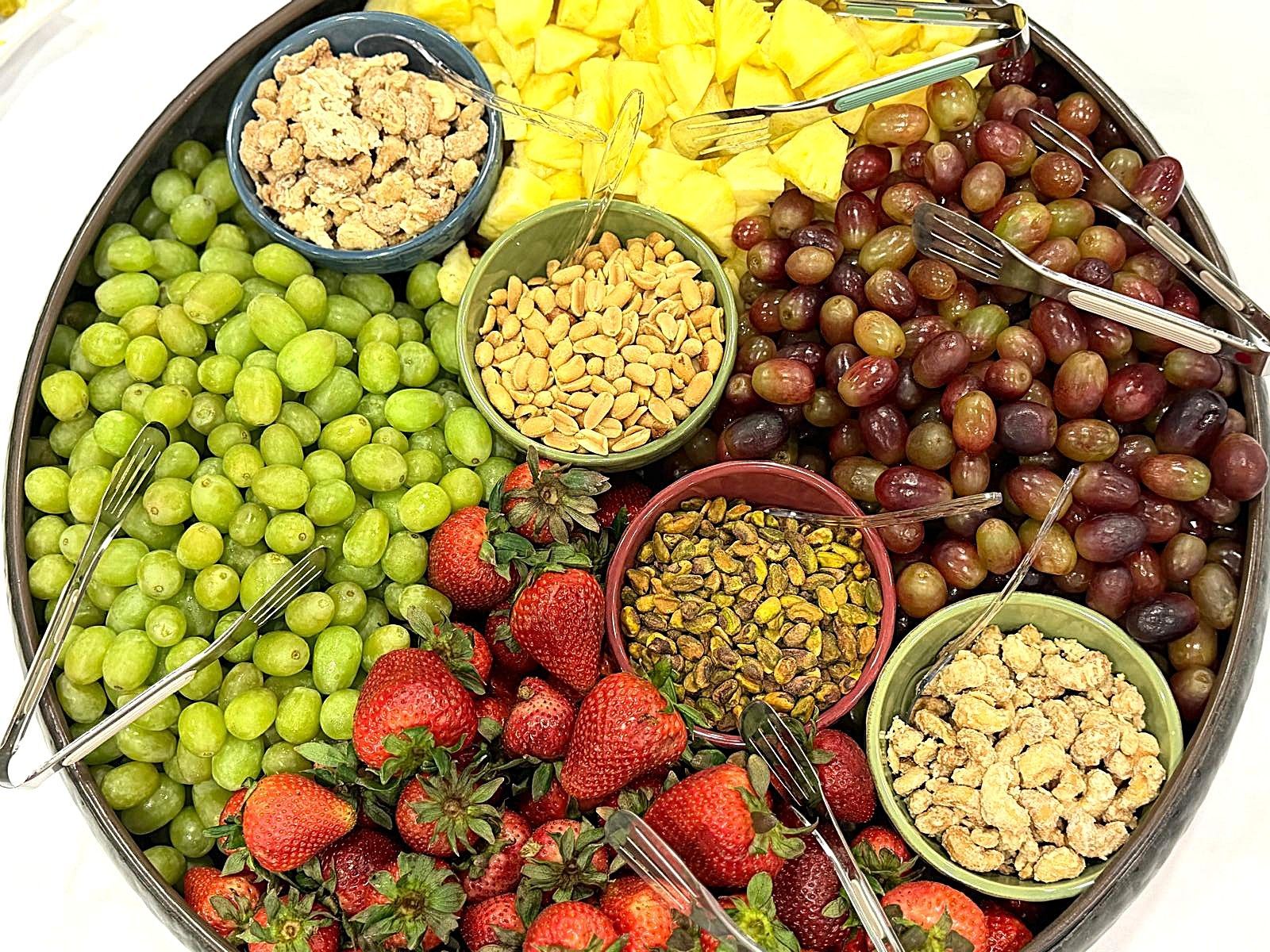 Assorted fruits and nuts arranged in a colorful circular tray display